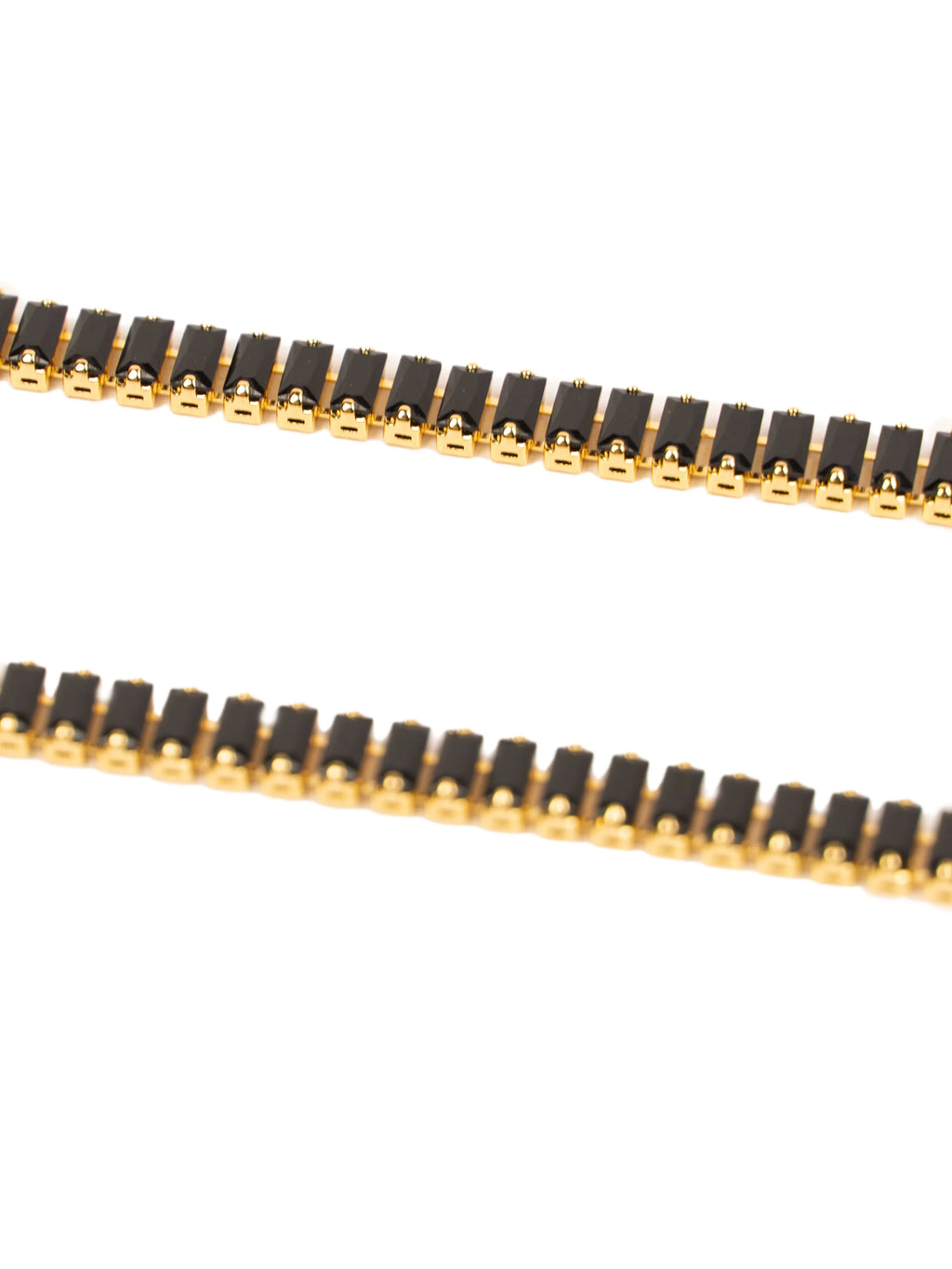 Close-up of a black and gold chain on a white background