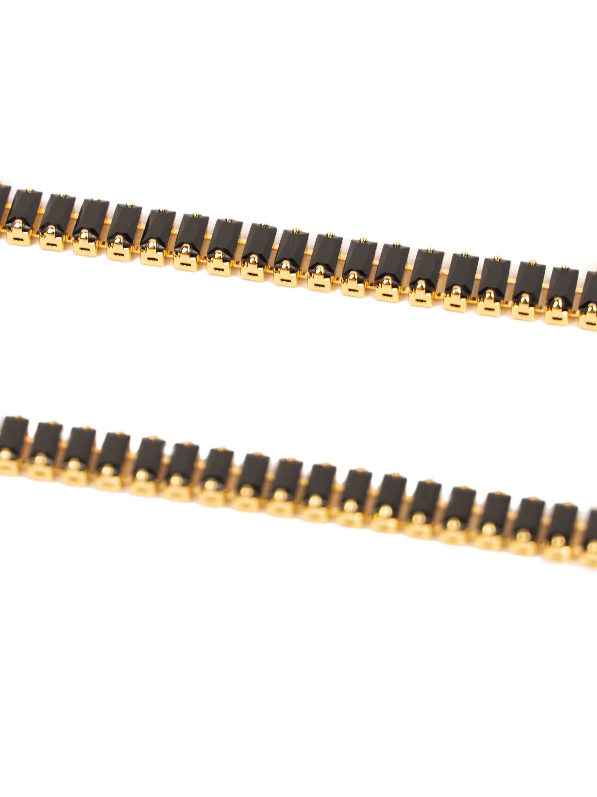 Close-up of a black and gold chain on a white background