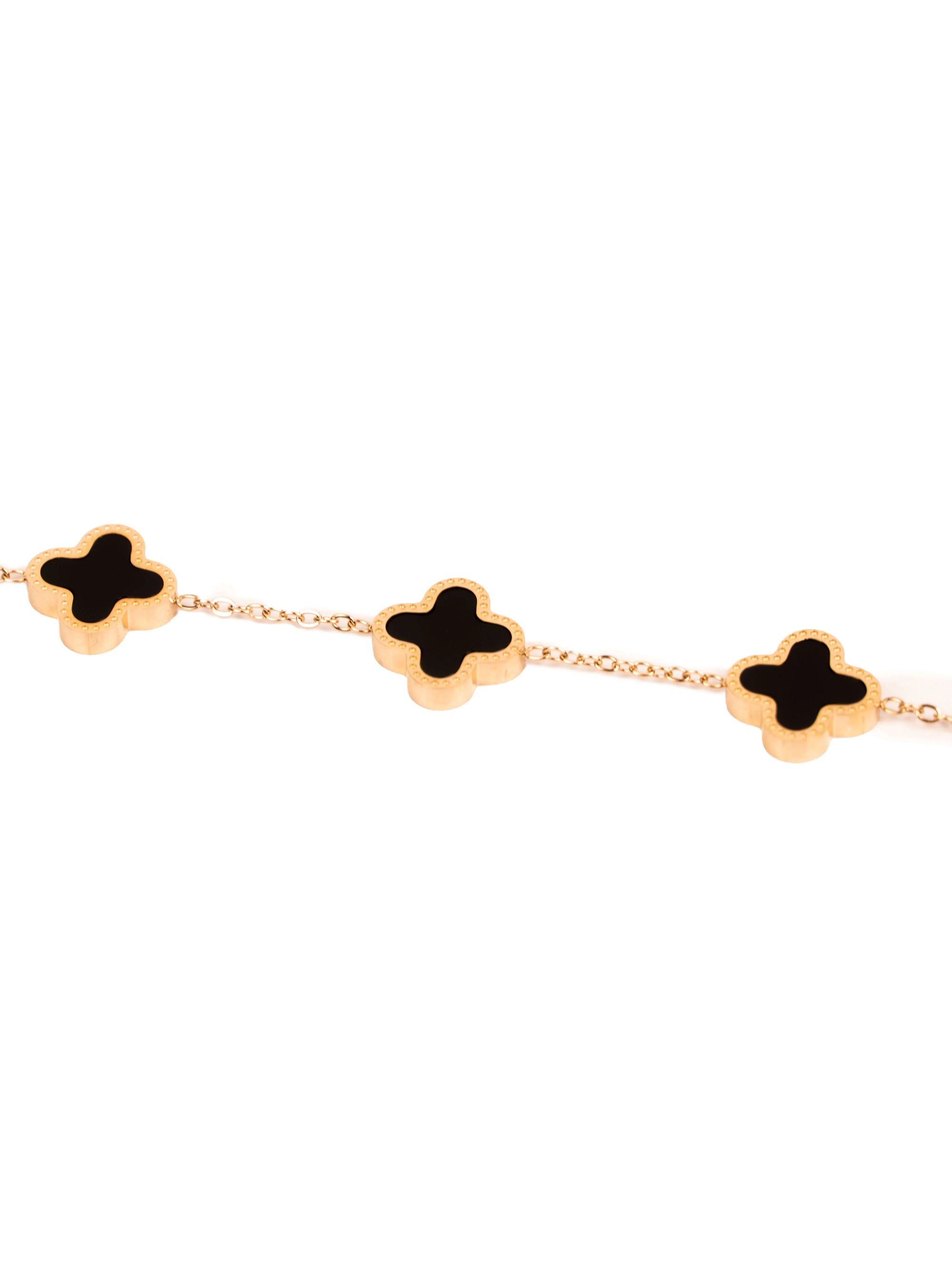 Gold bracelet with black clover-shaped charms on a white background