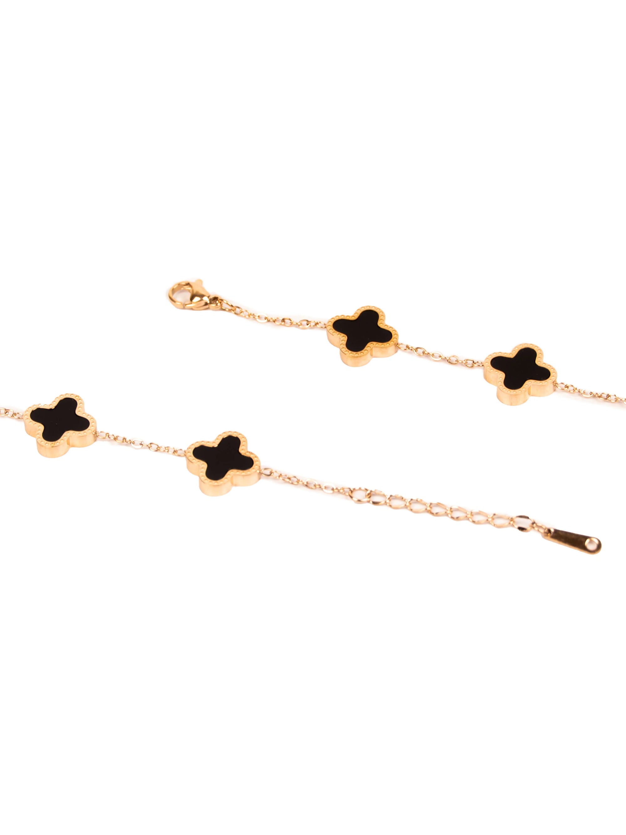 Gold bracelet with black clover-shaped charms on a white background