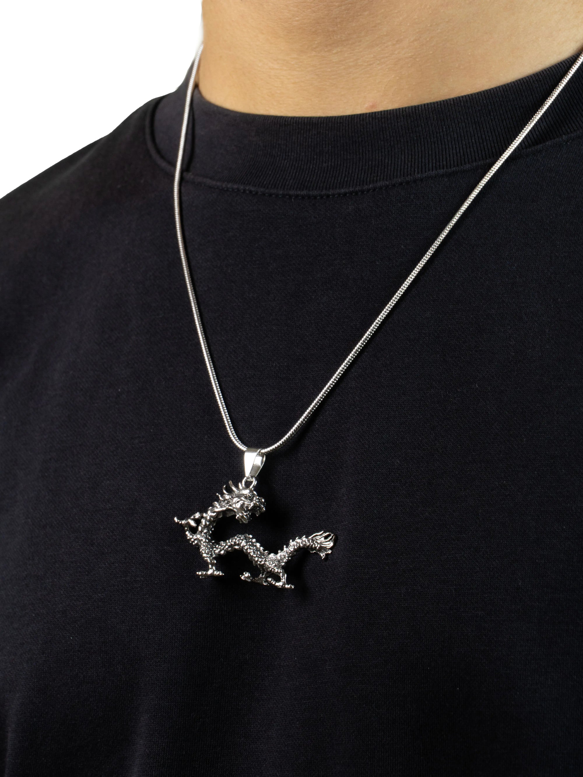 Silver dragon pendant necklace on a black shirt