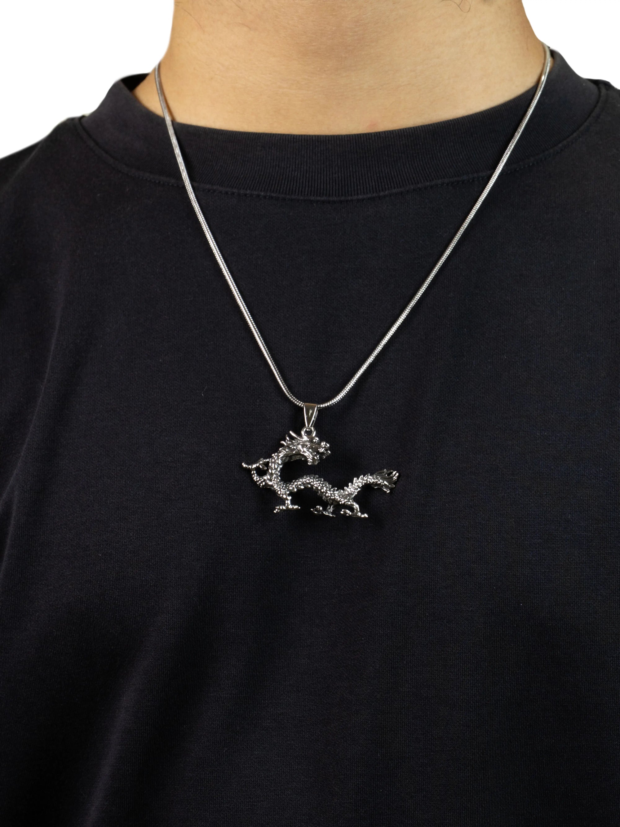 Silver dragon pendant necklace on a black shirt