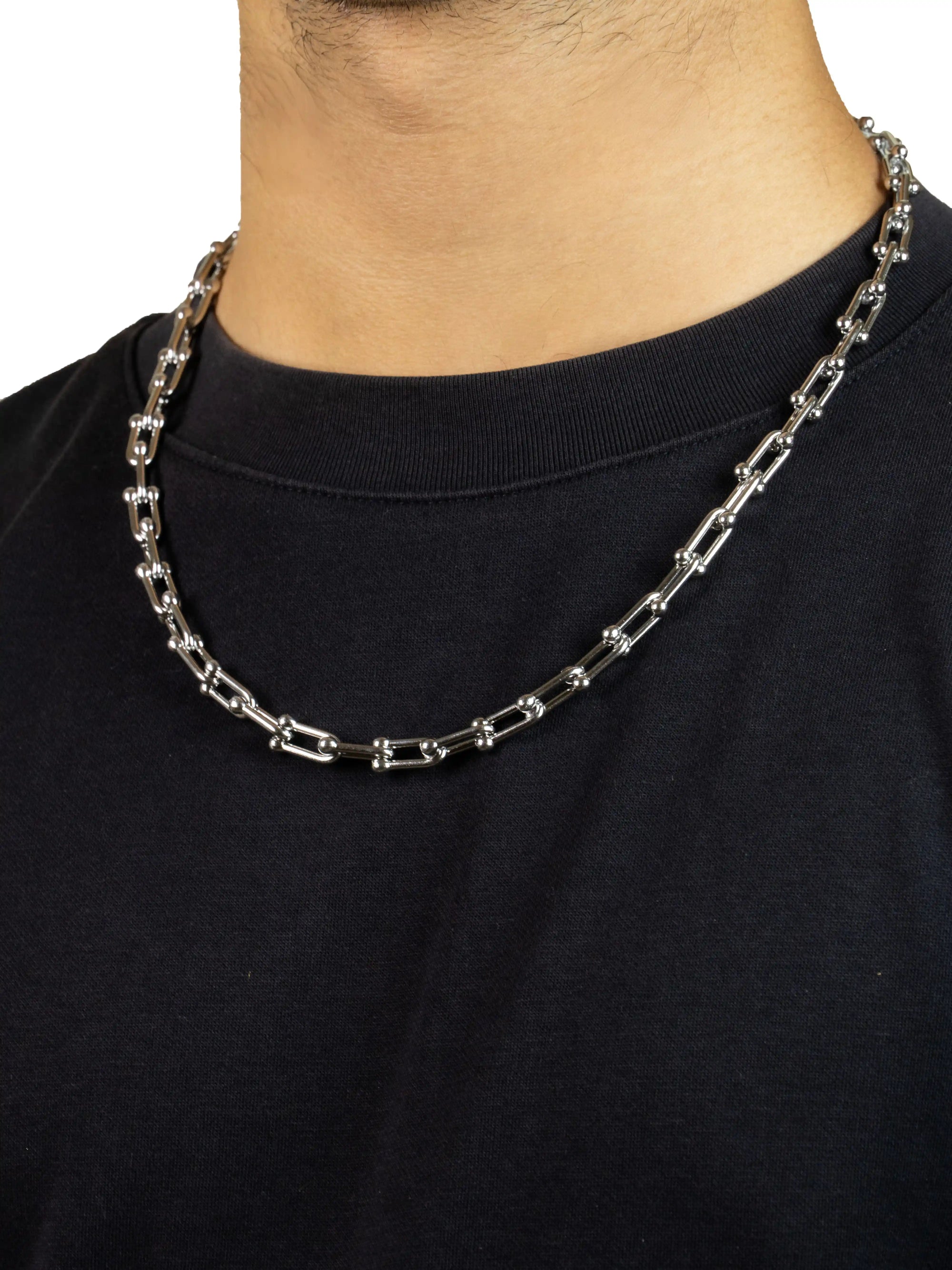 link chain , Silver chain necklace worn by a person on a black background