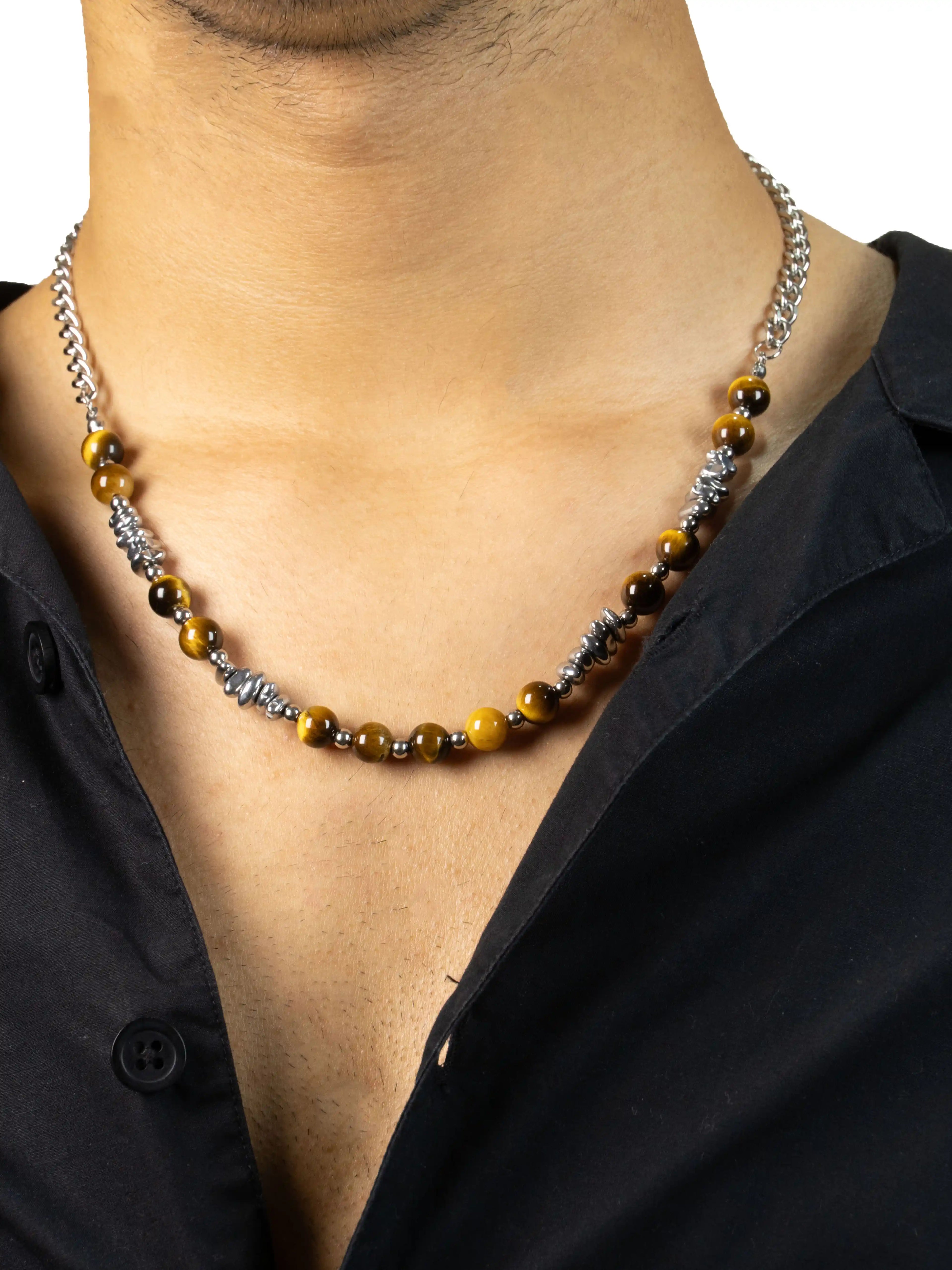 Necklace with yellow beads and silver accents worn by a person against a black shirt background
stawp
