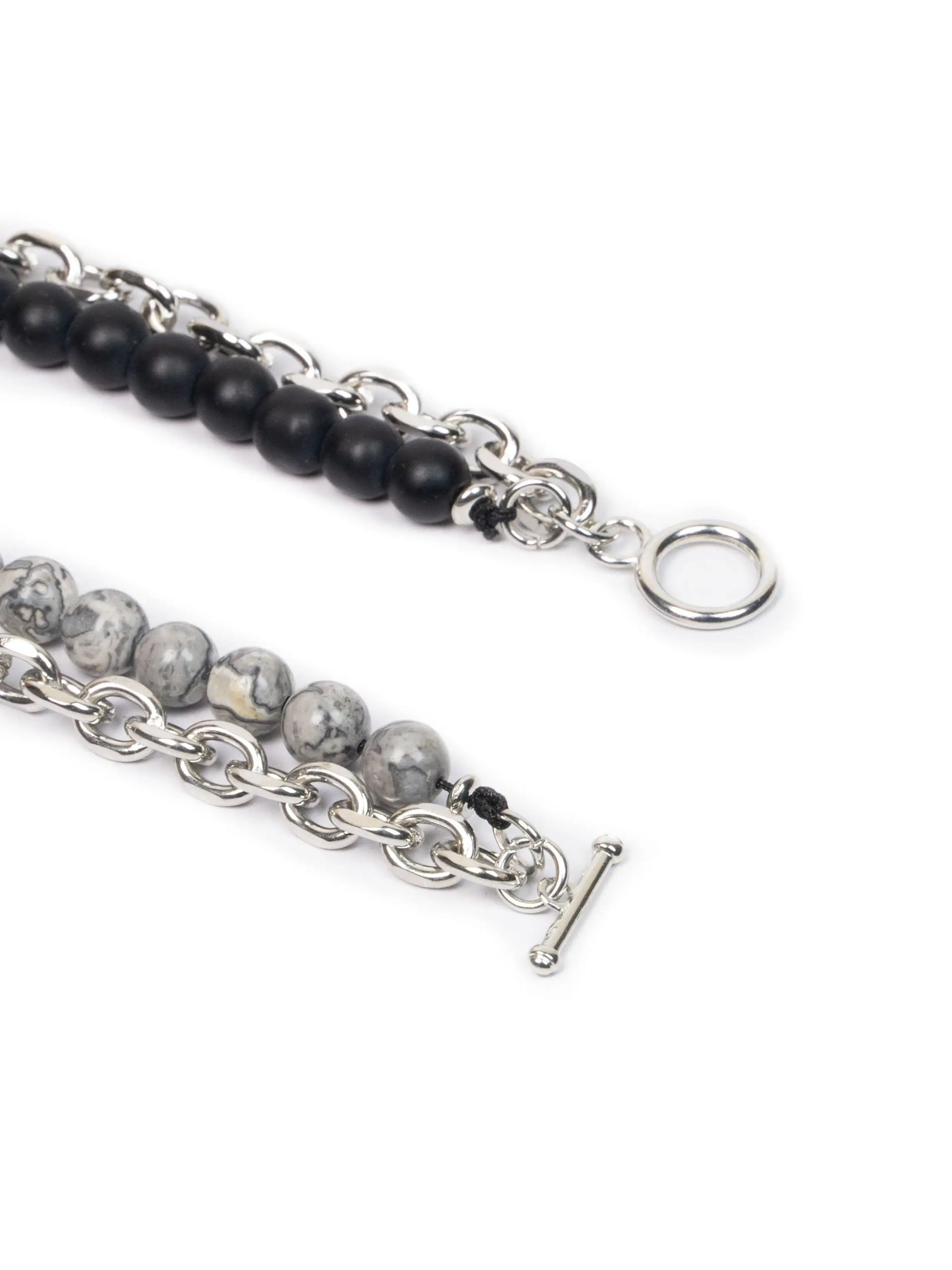 Two bracelets with black and gray beads on silver chains against a white background