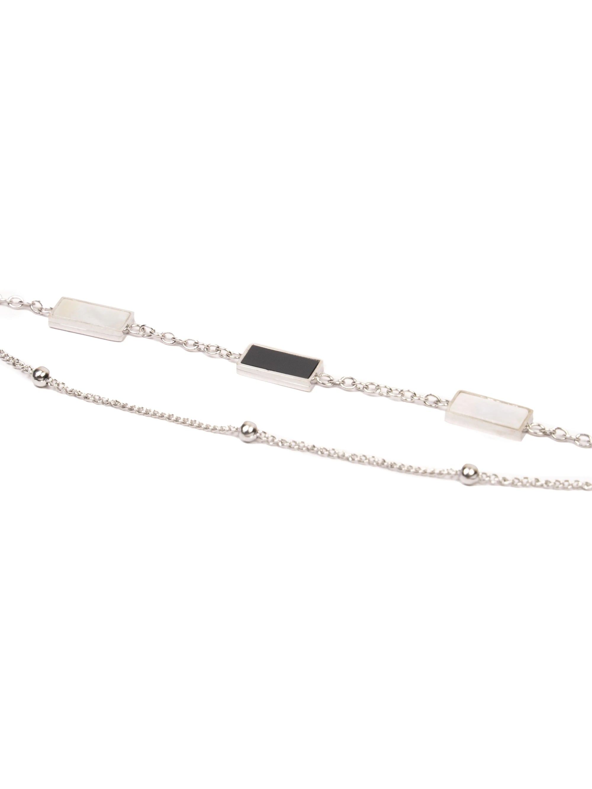 Silver necklace with black and white stone pendants on a white background