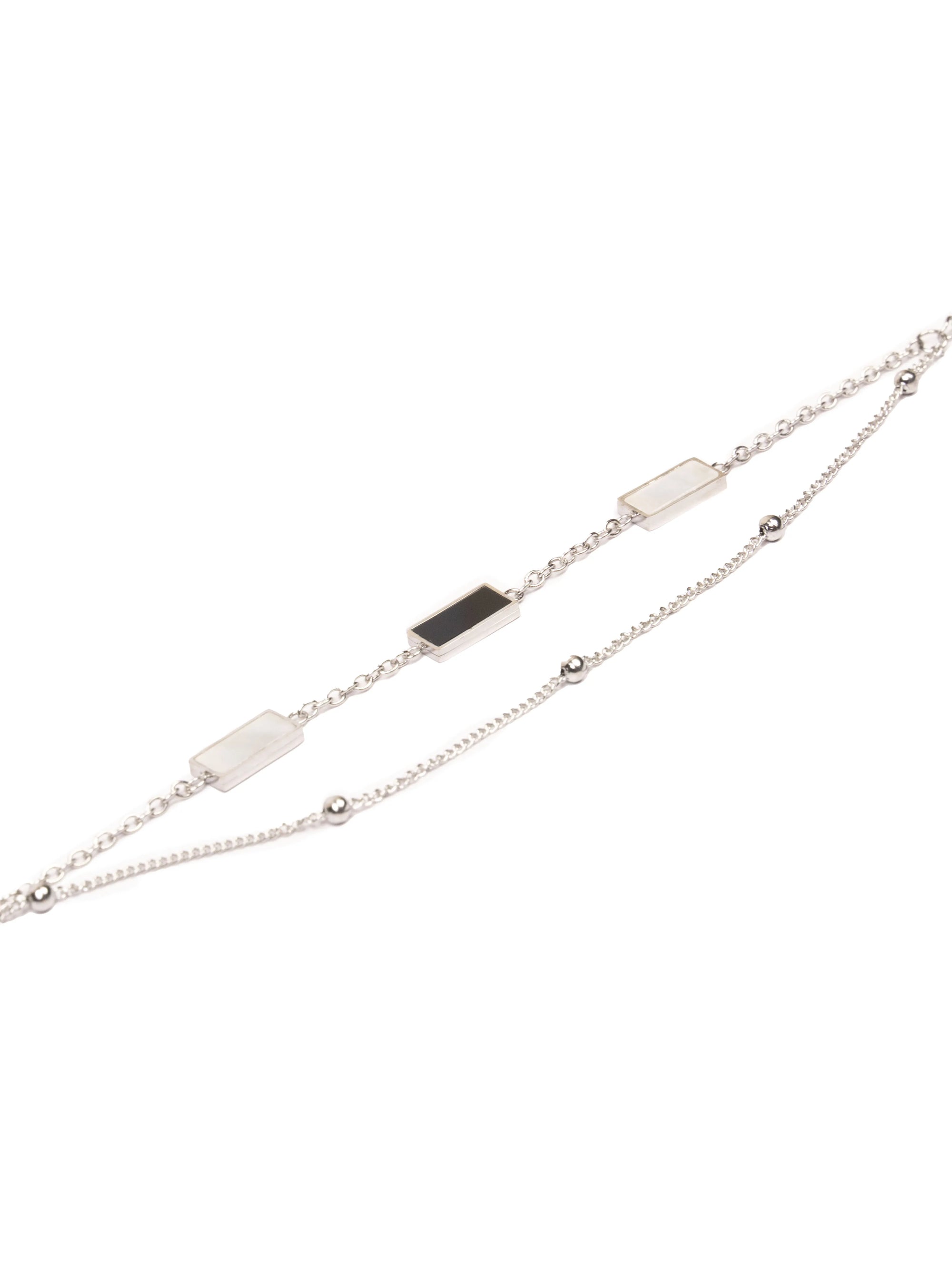 Silver bracelet with black and white stones on a white background